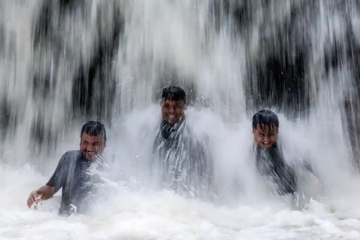 Du khách tắm mát dưới thác nước trong một ngày nắng nóng ở bên ngoài Kuala Lumpur, Malaysia hôm 30-4. Cục Khí tượng Malaysia đã ban hành cảnh báo nắng nóng cấp 1 cho 18 khu vực ở nước này - Ảnh: Fazry Ismail/EPA
