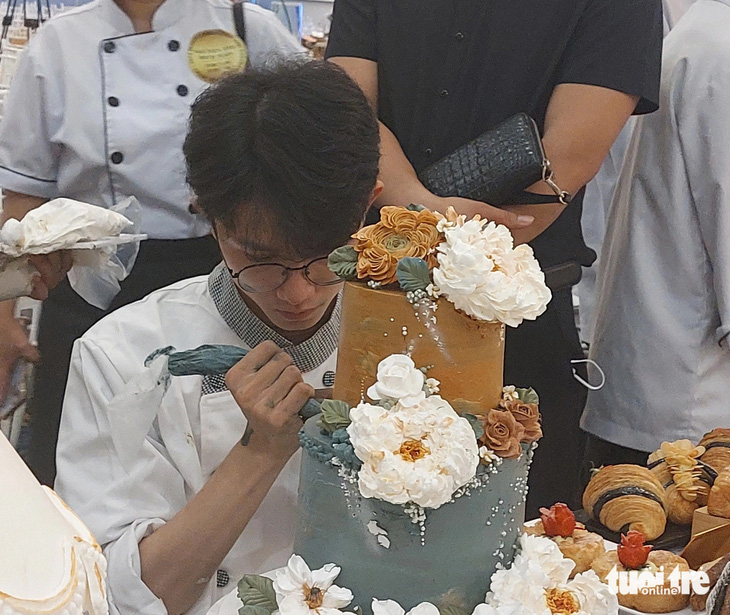 Thái Thịnh đang trang trí những chiếc lá trên bánh kem - Ảnh: HOÀNG LÊ