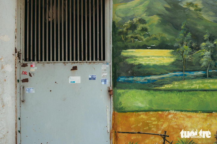 Căn nhà của một hộ dân trên đường Đỗ Tấn Phong, quận Phú Nhuận vẽ một bức tranh màu sắc. Tuy nhiên cánh cổng sát bên bị dán tờ rơi quảng cáo xấu xí - Ảnh: THANH HIỆP