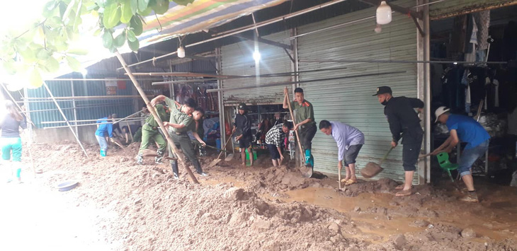 Lực lượng chức năng và người dân dọn dẹp bùn đất sau trận lũ quét - Ảnh: ĐIỆN BIÊN ĐÔNG
