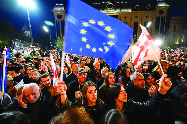 Người biểu tình ở Gruzia mang theo cờ EU. Ảnh: AFP