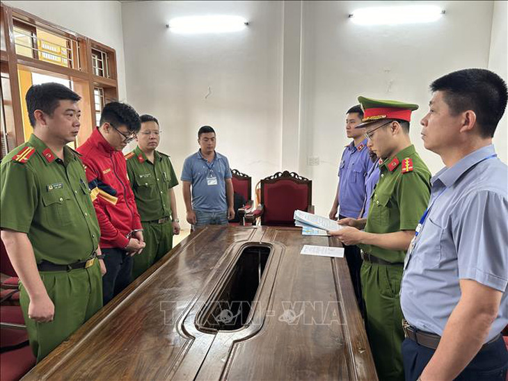 Cơ quan cảnh sát điều tra, Công an tỉnh Sơn La tổ chức thi hành các quyết định tố tụng đối với Lò Minh Phương (áo đỏ) - Ảnh: TTXVN