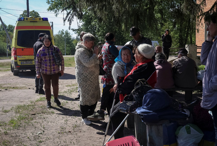 Cư dân tại Vovchansk và các ngôi làng lân cận chờ xe buýt khi di tản đến thành phố Kharkov vì lo sợ cuộc không kích của Nga ngày 10-5 - Ảnh: REUTERS 