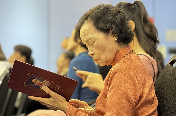 Người thân của liệt sĩ Vũ Duy Hùng đọc nhật ký được trao trả tại buổi lễ - Ảnh: D.LINH