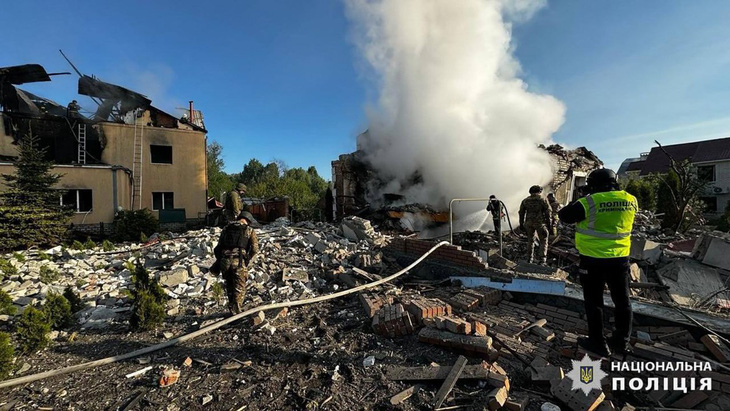 Ảnh do Cảnh sát Quốc gia Ukraine chụp và công bố hôm 10-5 cho thấy các nhân viên của Cơ quan Tình trạng khẩn cấp quốc gia đang dập tắt đám cháy tại những ngôi nhà bị phá hủy do Nga pháo kích ở Kharkov, Ukraine - Ảnh: AFP/Cảnh sát Quốc gia Ukraine