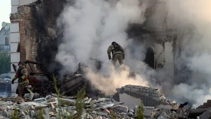 Nhân viên cứu hộ vào một ngôi nhà ở Kharkov sau một đợt không kích của Nga - Ảnh: UKRINFORM