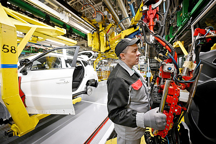 Nhân viên nhà máy sản xuất ô tô Moskvich làm việc với dây chuyền sản xuất vào ngày 18-4-2024 - Ảnh: AFP