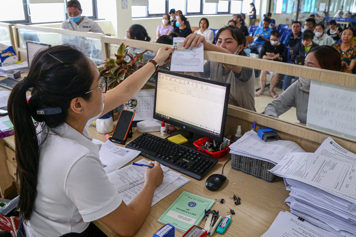 Cán bộ Trung tâm Dịch vụ việc làm Bắc Giang hướng dẫn người lao động hoàn thiện hồ sơ bảo hiểm thất nghiệp - Ảnh: HÀ QUÂN