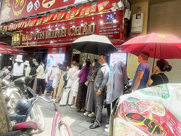 Bất chấp giá vàng lên cao nhất lịch sử, nhiều người ở Hà Nội đội nắng xếp hàng chờ mua vàng (ảnh chụp tại trước cửa hàng kinh doanh vàng trên phố Trần Nhân Tông vào ngày 10-5) - Ảnh: LÊ THANH