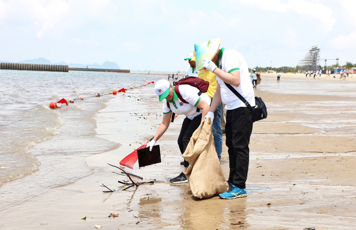 Các đại biểu thu gom rác tại khu vực bờ biển dài khoảng 1km ở Hạ Long, Quảng Ninh - Ảnh: T.DƯƠNG
