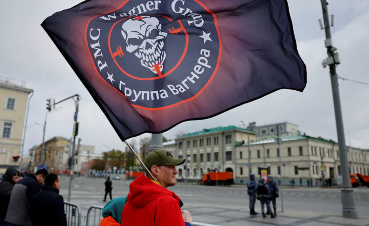 Một người Nga cầm cờ của tập đoàn lính đánh thuê Wagner trong buổi lễ duyệt binh Ngày Chiến thắng 9-5 - Ảnh: REUTERS