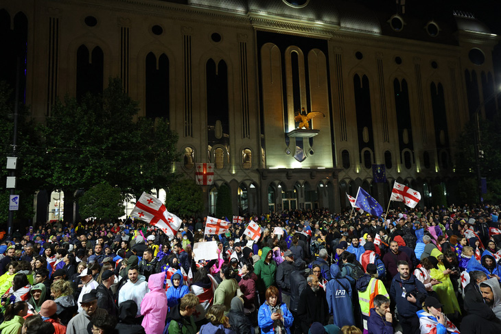 Những người biểu tình vẫy cờ Georgia và EU bên ngoài tòa nhà Quốc hội vào tối 12-5, để phản đối dự luật "đại diện nước ngoài" gây tranh cãi - Ảnh: AFP