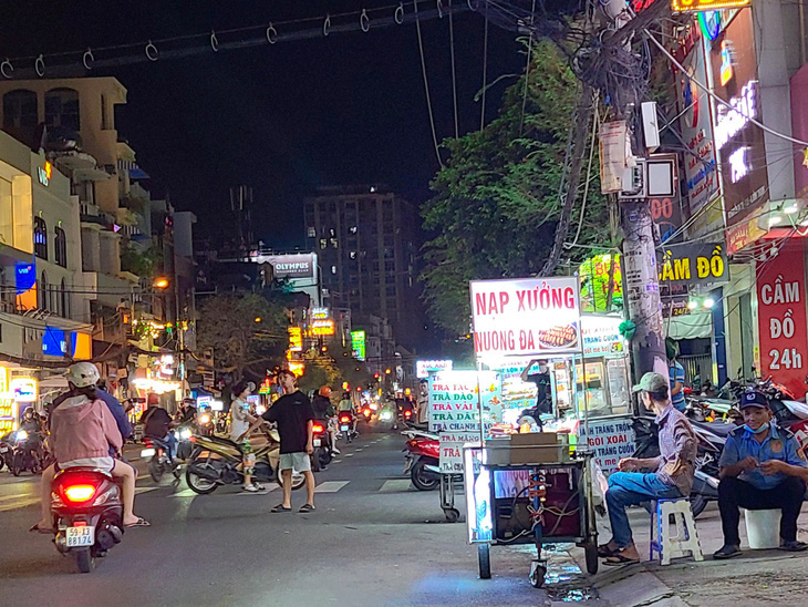 Mời chào mua hàng của người bán hàng rong và các xe đẩy trên đường Nguyễn Gia Trí, quận Bình Thạnh - Ảnh: NHẬT XUÂN