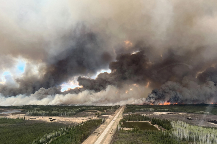Ảnh chụp qua cửa sổ cho thấy khói bốc lên do cháy rừng gần cộng đồng Indian Cabins, tỉnh bang Alberta, Canada hôm 10-5 - Ảnh: REUTERS