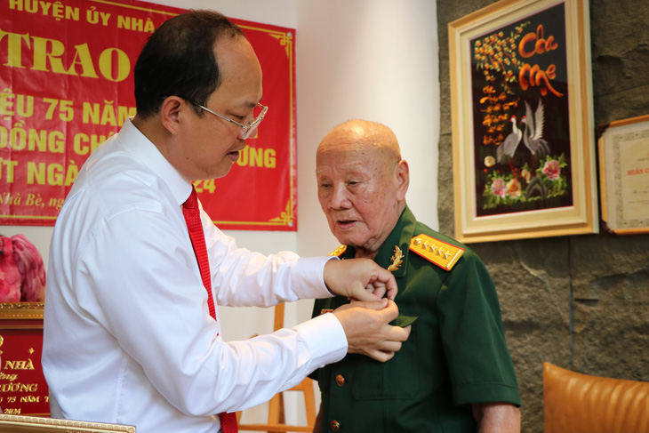 Lãnh đạo Thành ủy trao huy hiệu 75 năm tuổi Đảng cho ông Trương - Ảnh: CẨM NƯƠNG 