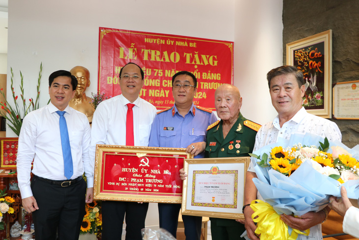 Huyện ủy Nhà Bè chúc mừng ông Phạm Trương và gia đình tại buổi lễ trao huy hiệu Đảng - Ảnh: CẨM NƯƠNG 