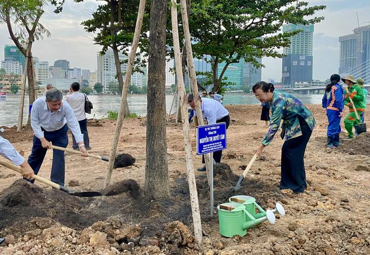 Các đại biểu, cựu lãnh đạo TP.HCM trồng cây bên bờ sông Sài Gòn (phía Thủ Thiêm) vào cuối năm 2023 - Ảnh: CHÂU TUẤN