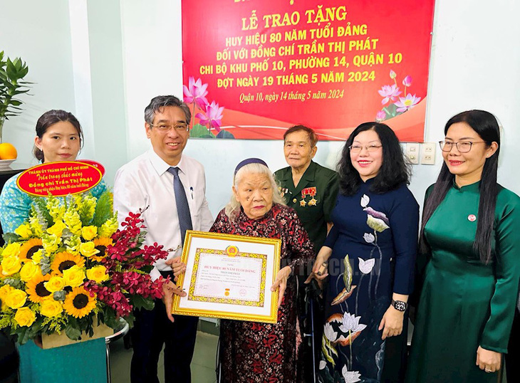 Ông Nguyễn Phước Lộc cùng các đại biểu trao huy hiệu 80 năm tuổi Đảng cho bà Trần Thị Phát - Ảnh: THÀNH ỦY TP.HCM