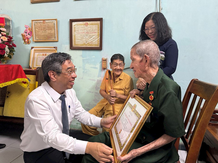 Phó bí thư Thành ủy TP.HCM trao huy hiệu 80 năm tuổi Đảng cho ông Trần Văn Ấn - Ảnh: THÀNH ỦY TP.HCM