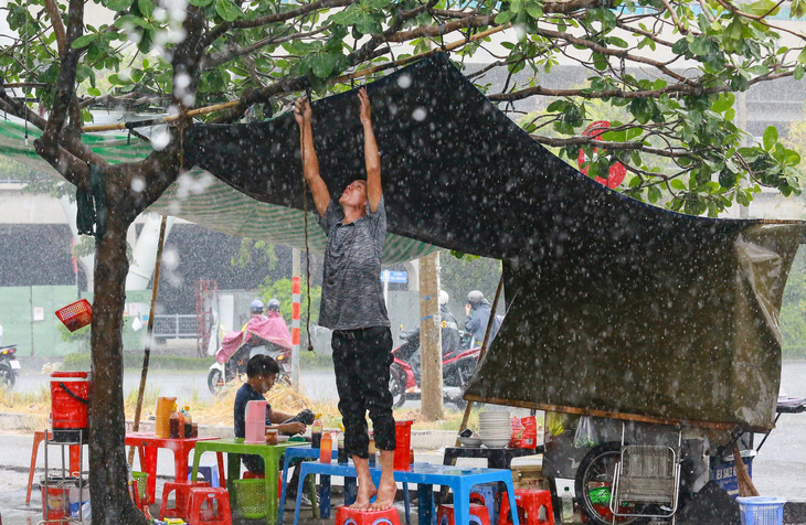 Người dân buôn bán che chắn tạm để tránh mưa - Ảnh: LÊ PHAN