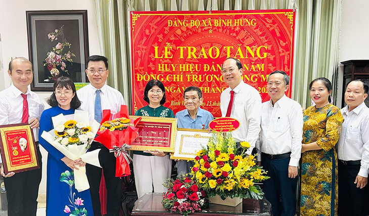 Ông Nguyễn Hồ Hải cùng các thành viên trong đoàn trao huy hiệu Đảng cho ông Trương Công Minh - Ảnh: THÀNH ỦY TP.HCM