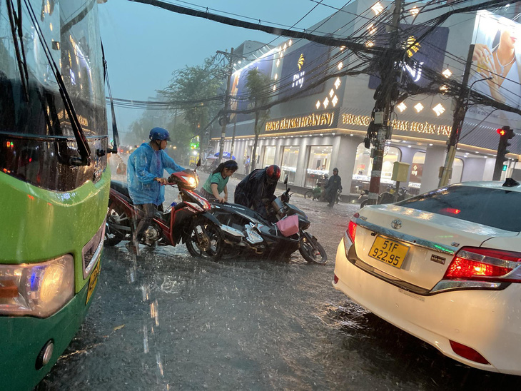 Nước bắt đầu dâng cao, chảy xiết tại tuyến đường Nguyễn Văn Khối (quận Gò Vấp, TP.HCM) khiến việc đi lại gặp nhiều khó khăn - Ảnh: TIẾN QUỐC