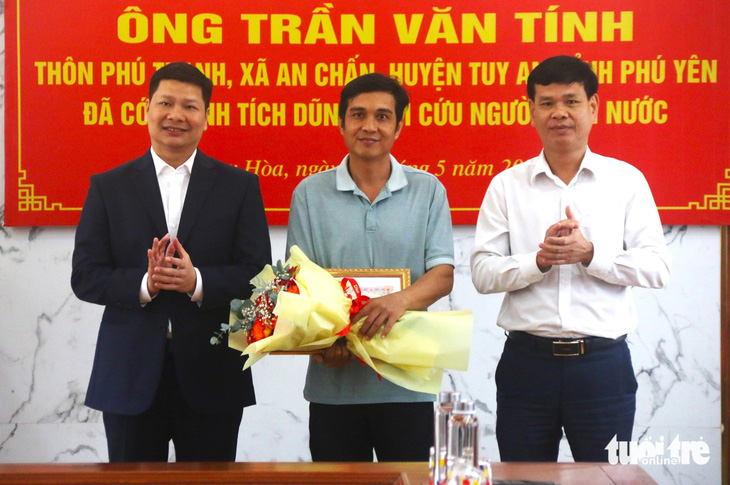 Chủ tịch UBND TP Tuy Hòa Cao Đình Huy (bìa trái) trao giấy khen cho anh Trần Văn Tính (giữa) vì có hành động dũng cảm cứu người bị đuối nước - Ảnh: NGUYỄN HOÀNG