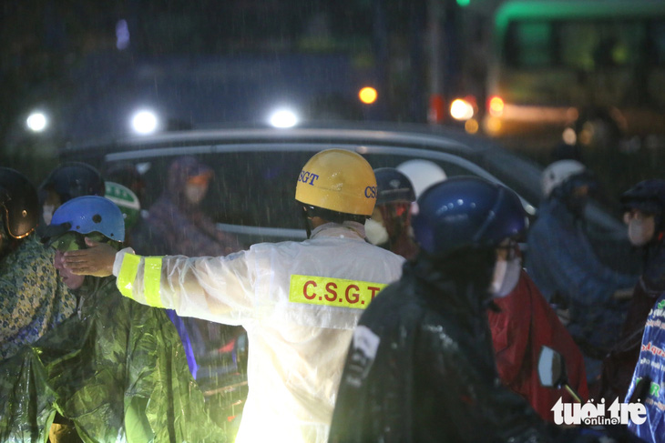 Lực lượng cảnh sát giao thông TP Thủ Đức có mặt phân luồng, điều tiết giao thông dưới mưa - Ảnh: MINH HÒA