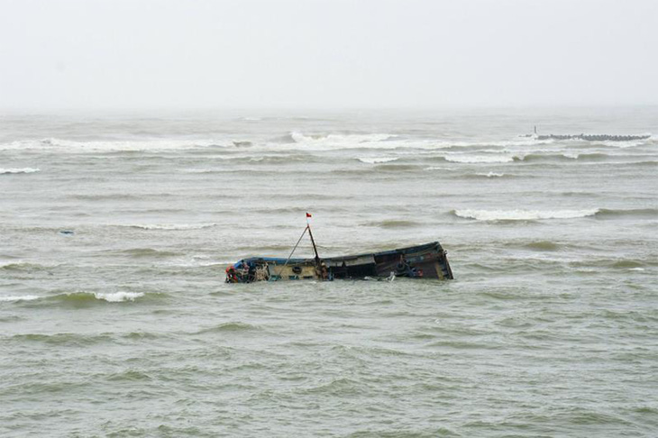 Một tàu cá bị chìm tại cửa biển Cửa Tùng do luồng lạch bị cạn, phải vứt bỏ tàu - Ảnh: ĐÌNH TIẾN