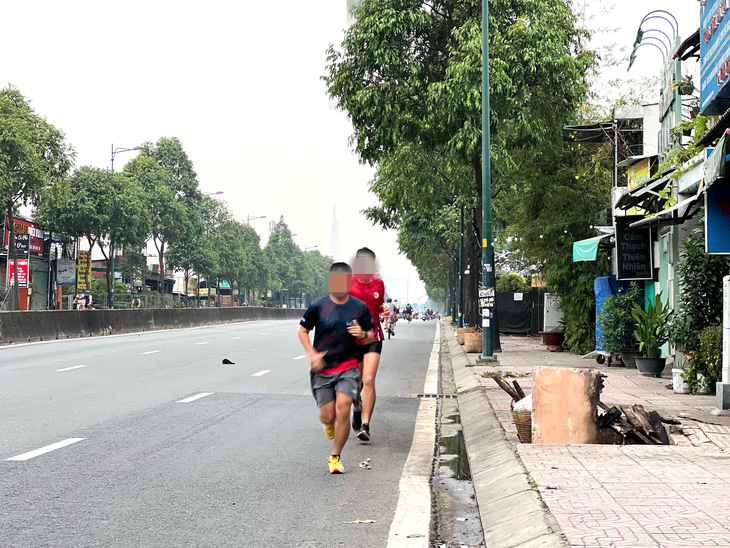 Chạy bộ ngược chiều dưới lòng đường Phạm Văn Đồng - Ảnh: XUÂN ĐOÀN