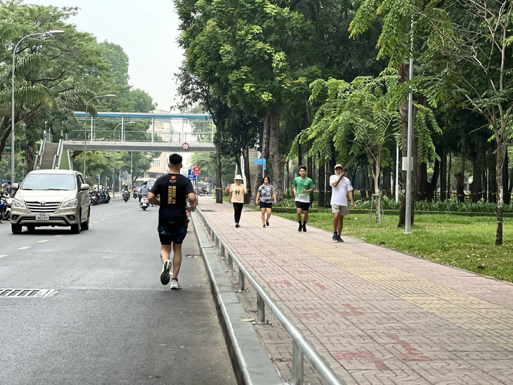 Dù có vỉa hè rộng và thoáng, một thanh niên vẫn chạy bộ dưới lòng đường Đặng Văn Sâm, quận Gò Vấp - Ảnh: XUÂN ĐOÀN