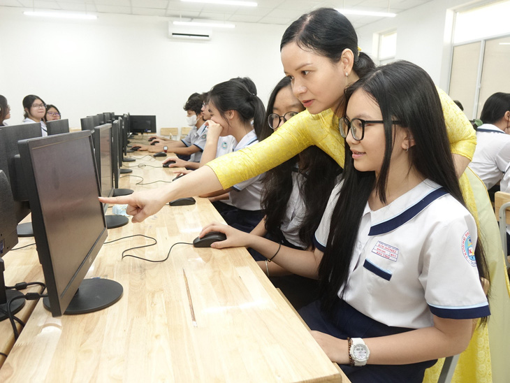 Giáo viên chủ nhiệm lớp 9/11 Trường THCS Kim Đồng Q.5, TP.HCM đang hướng dẫn học sinh cách đăng ký tuyển sinh lớp 10 sáng 6-5 - Ảnh: NHƯ HÙNG