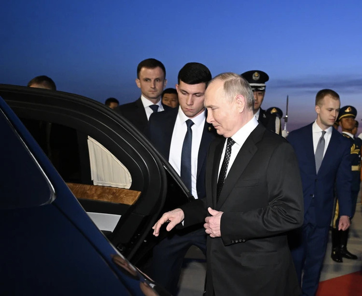 Tổng thống Nga Putin bước lên chiếc Aurus sau khi hạ cánh xuống Bắc Kinh sáng 16-5 - Ảnh: KOMMERSANT