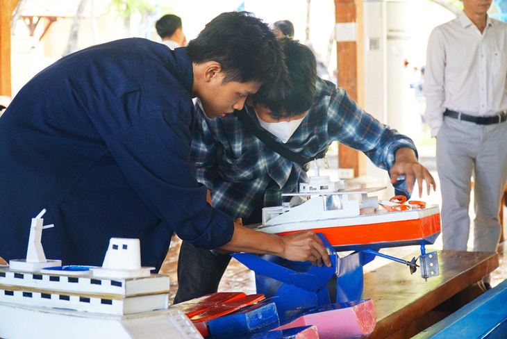 Các bạn sinh viên chuẩn bị sản phẩm tàu thủy đã thiết kế trước khi vào cuộc thi - Ảnh: TRẦN HOÀI