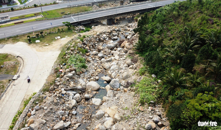 Nước suối nhỏ giọt chảy đoạn dưới cầu đường dẫn vào hầm Hải Vân - Ảnh: ĐOÀN CƯỜNG