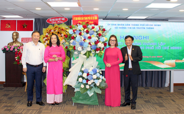 Phó chủ tịch UBND TP.HCM Dương Anh Đức (bìa trái) tặng hoa chúc mừng Trung tâm báo chí TP.HCM - Ảnh: T.N.
