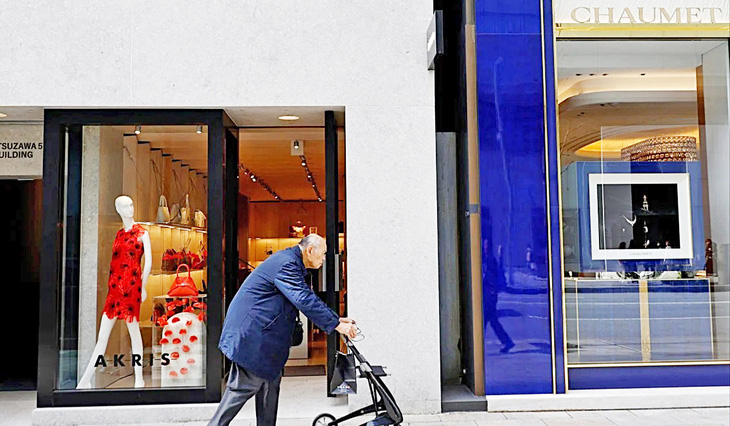Một cụ ông đi bộ trong khu phố mua sắm ở thủ đô Tokyo, Nhật Bản  - Ảnh: Reuters