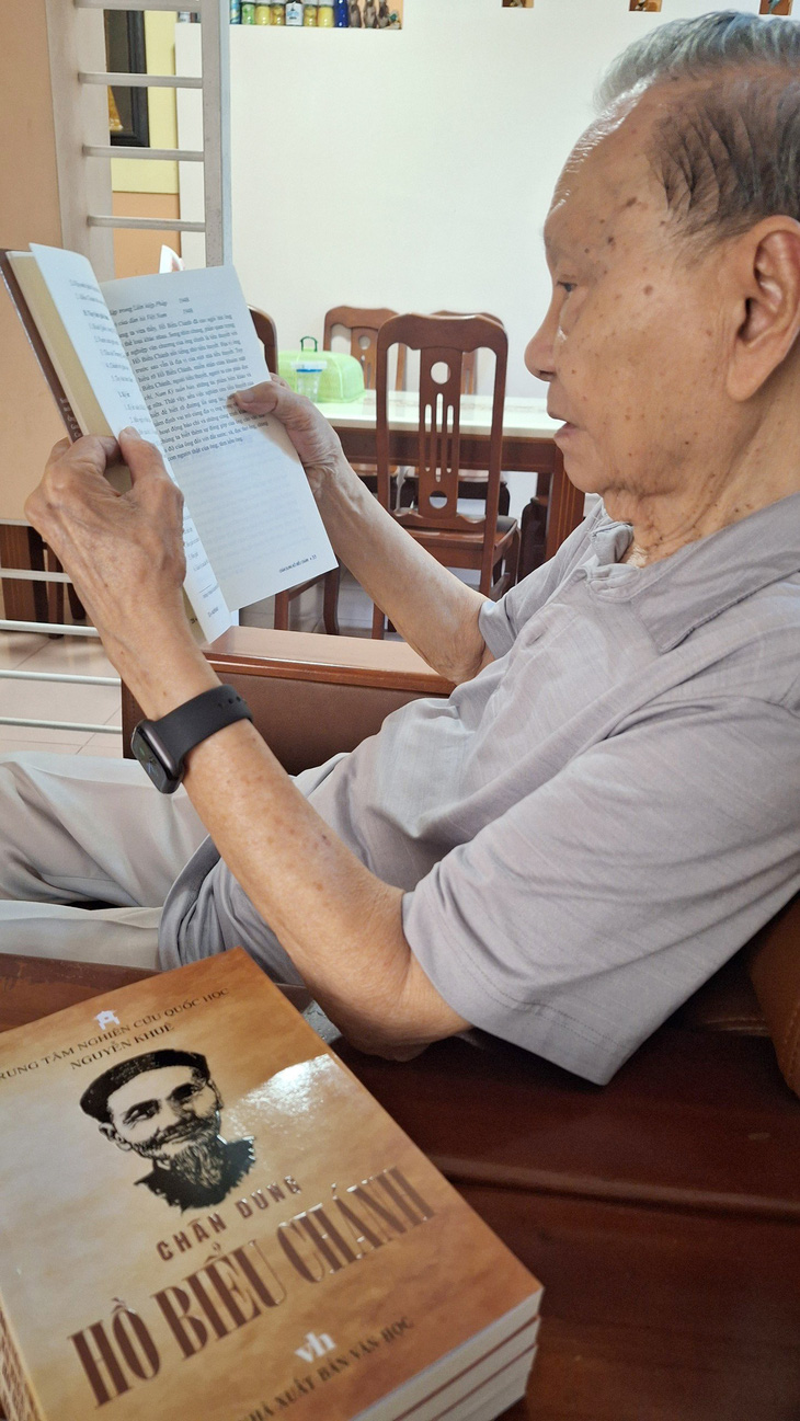 Giáo sư Nguyễn Khuê bên cạnh công trình nghiên cứu về Hồ Biểu Chánh của mình - Ảnh: NGỌC HÂN