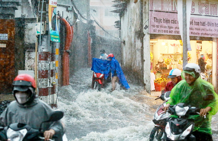 Nước chảy cuồn cuộn trên đường Võ Văn Ngân (TP Thủ Đức) trong trận mưa chiều 15-5  - Ảnh: CHÂU TUẤN