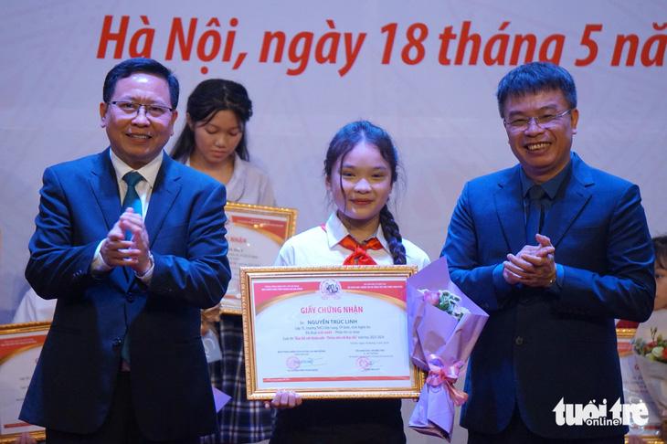 Ban tổ chức cuộc thi Bác Hồ với thiếu nhi - Thiếu nhi với Bác Hồ trao giải nhất cho em Nguyễn Trúc Linh - Ảnh: T.ĐIỂU