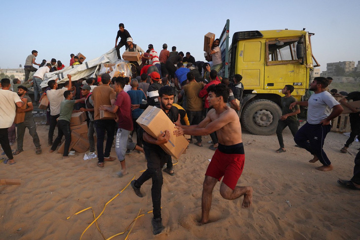 Một số người Palestine lao vào tranh nhau các thùng hàng viện trợ nhân đạo quốc tế ở bến cảng Trident do Mỹ xây dựng gần trại tị nạn Nuseirat ở miền trung Dải Gaza hôm 18-5 - Ảnh: AFP