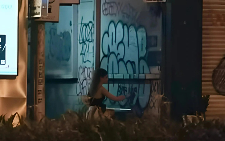 Đoạn clip ghi hình người phụ nữ nước ngoài mặc áo đen đang xịt sơn vẽ bậy tại một con hẻm trên đường Lê Lợi (quận 1, TP.HCM) - Ảnh: Chụp màn hình