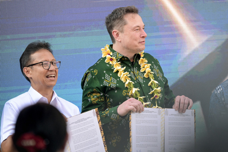 Tỉ phú Elon Musk (phải) giơ thỏa thuận triển khai dịch vụ Starlink trong buổi lễ ngày 19-5 tại Bali - Ảnh: AFP