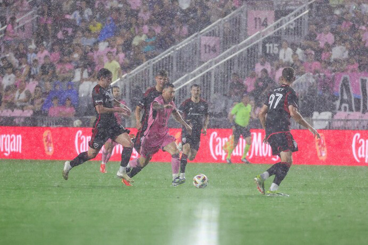 Messi đi bóng trước cầu thủ DC United trong cơn mưa nặng hạt trên sân Chase - Ảnh: AP