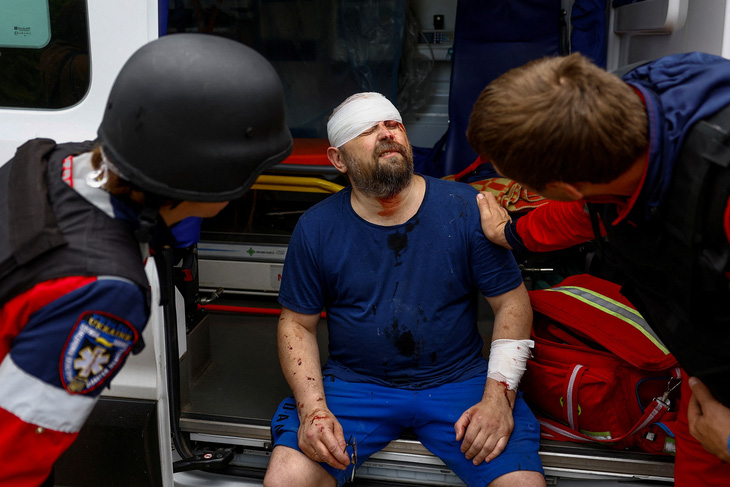 Nhân viên y tế sơ cứu ông Oleksii, 47 tuổi, bị thương trong cuộc không kích của Nga ở Kharkov, Ukraine - Ảnh: REUTERS