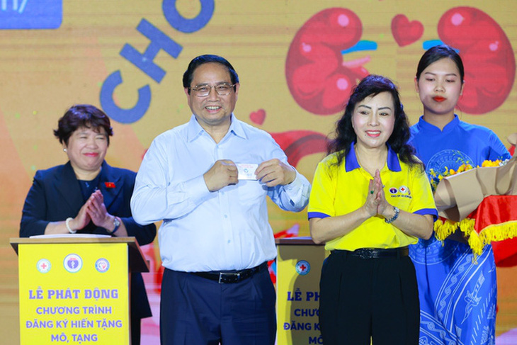 Bà Nguyễn Thị Kim Tiến - Chủ tịch Hội vận động hiến tặng mô tạng, bộ phận cơ thể người Việt Nam - trao cho Thủ tướng thẻ đăng ký hiến tặng mô, tạng - Ảnh: VGP