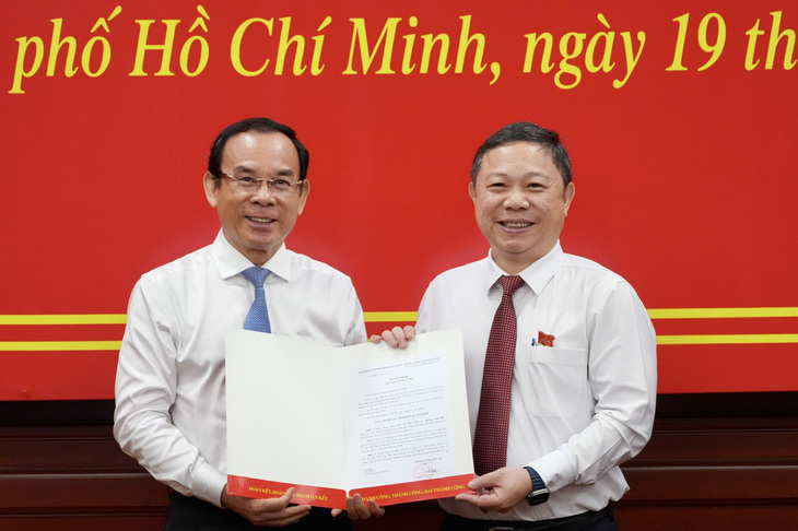 Bí thư Thành ủy TP.HCM Nguyễn Văn Nên trao quyết định cho ông Dương Anh Đức (bên phải) - Ảnh: HỮU HẠNH