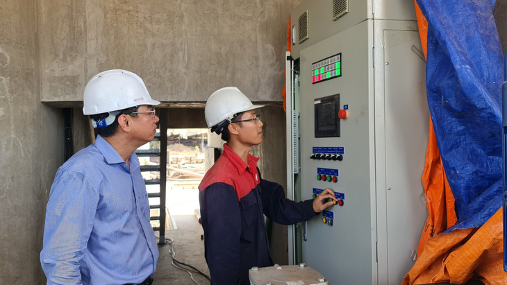 Các công nhân, kỹ sư đang vận hành mở cống Nguyễn Tấn Thành thông qua hệ thống điều khiển tự động - Ảnh: MẬU TRƯỜNG   