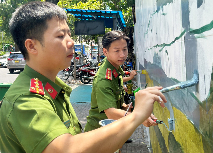 Các chiến sĩ công an cùng tham gia hoàn thành công trình bích họa 