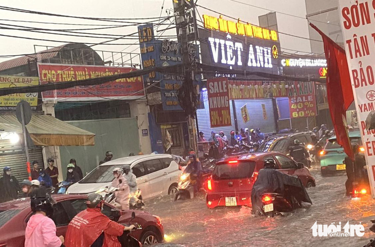 Đến 18h, giao thông khá lộn xộn trên đường Lê Văn Việt. Nhiều người không đi nổi nữa đã dắt xe vào lề chờ qua cơn mưa lớn - Ảnh: THU DUNG